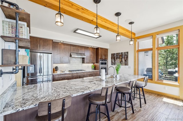 50 Spinning Leaf Trl, Silverthorne, CO 80498 - kitchen featuring appliances with stainless steel finishes, under cabinet range hood, beam ceiling, a sink, and baseboards