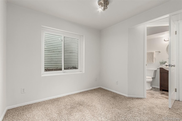 1451 S Quitman St, Denver, CO 80219 - unfurnished bedroom with light carpet, baseboards, and ensuite bathroom