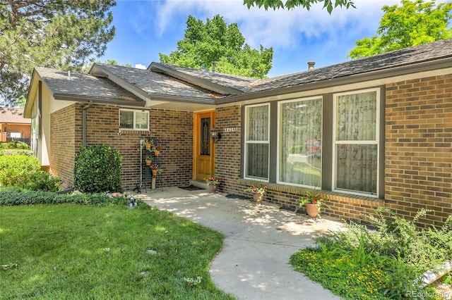 6425 W Frost Dr, Littleton, CO 80128 - view of front of home featuring brick siding and a front lawn