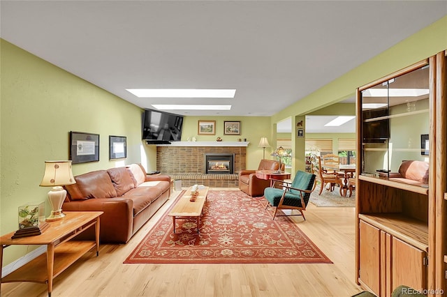 6425 W Frost Dr, Littleton, CO 80128 - living area featuring a skylight, wood finished floors, and a brick fireplace