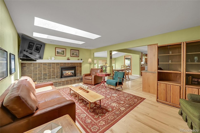 6425 W Frost Dr, Littleton, CO 80128 - living room with a skylight, a brick fireplace, and light wood finished floors