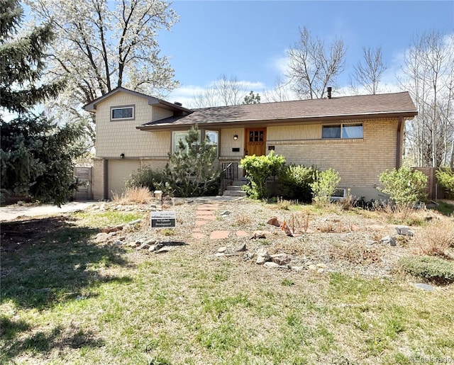 tri-level home with a garage and brick siding