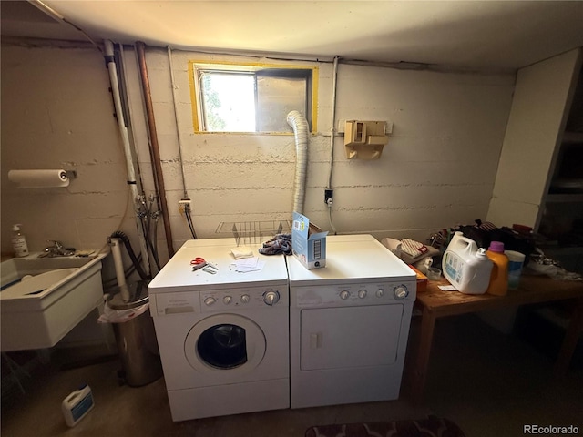 laundry area with laundry area, a sink, and washer and clothes dryer