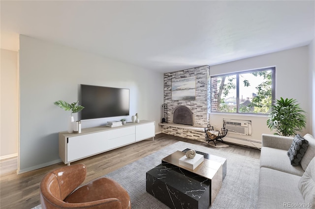 1008 N Corona St Unit 403, Denver, CO 80218 - living room with a large fireplace, a wall mounted air conditioner, wood finished floors, and baseboards