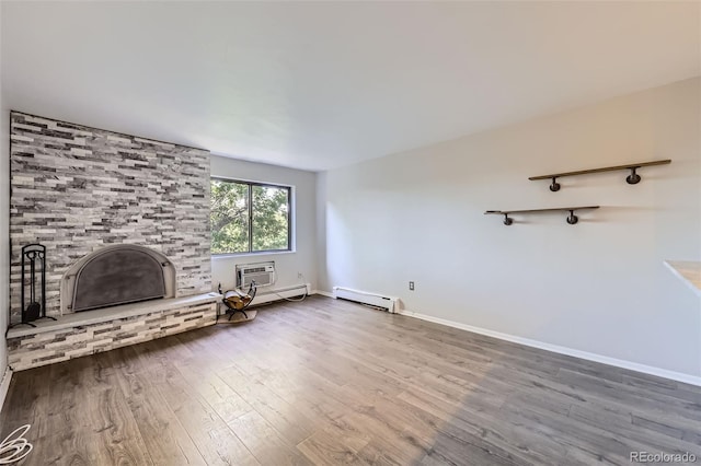 1008 N Corona St Unit 403, Denver, CO 80218 - unfurnished living room featuring wood finished floors, a baseboard heating unit, an AC wall unit, and baseboards