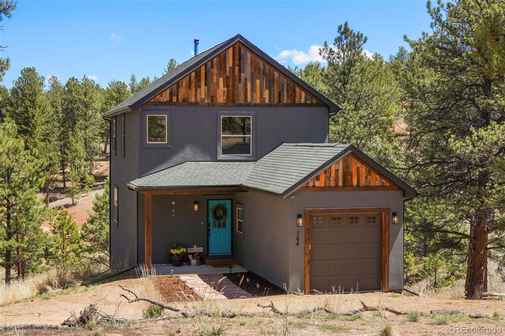 364 Phoebus Dr, Florissant, CO 80816 - view of front of home with stucco siding, a garage, and a shingled roof