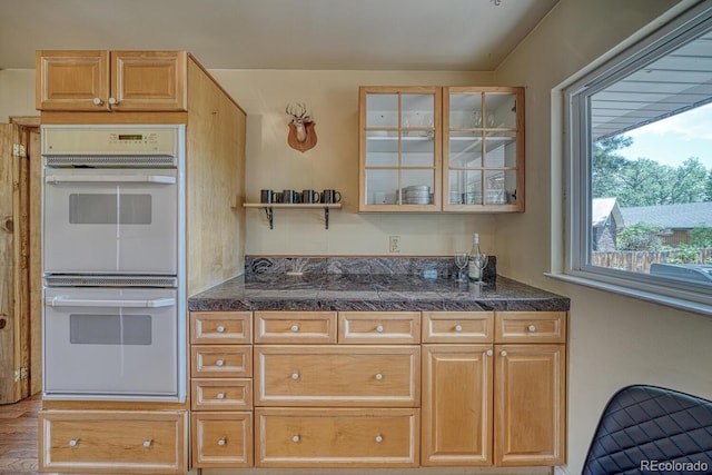 kitchen with glass insert cabinets, tile countertops, and white double oven