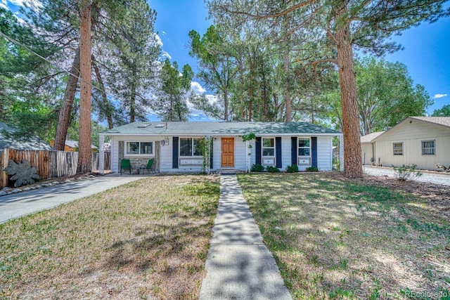 ranch-style house featuring a front yard and fence