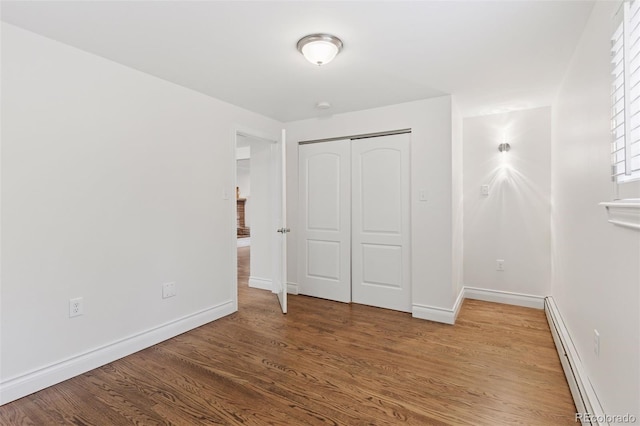3190 S Detroit St, Denver, CO 80210 - unfurnished bedroom with wood finished floors, a closet, and a baseboard radiator