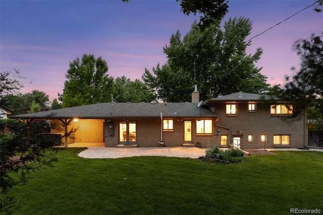 3190 S Detroit St, Denver, CO 80210 - back of property featuring a patio area, a lawn, a chimney, and brick siding