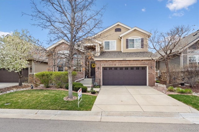 traditional-style house featuring an attached garage, a front lawn, brick siding, and driveway