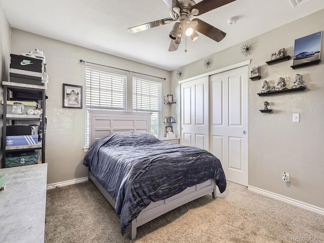 carpeted bedroom with a closet, ceiling fan, baseboards, and a textured wall