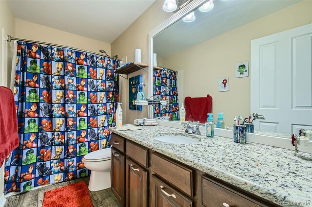 bathroom featuring vanity, a shower with shower curtain, and toilet