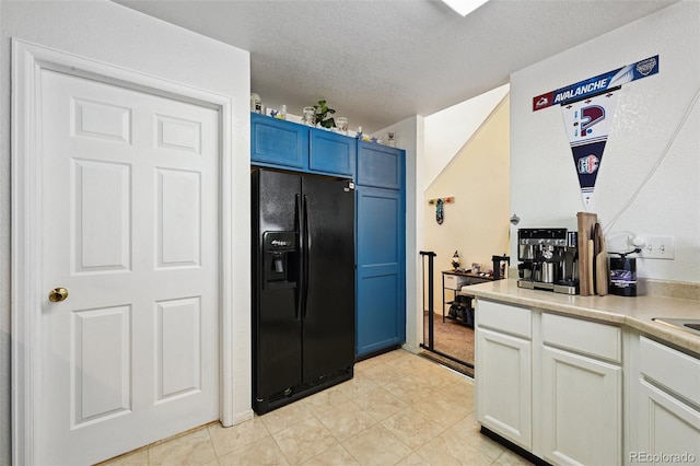 10223 Vine Ct, Thornton, CO 80229 - kitchen with black refrigerator with ice dispenser, light countertops, a textured ceiling, blue cabinets, and white cabinetry
