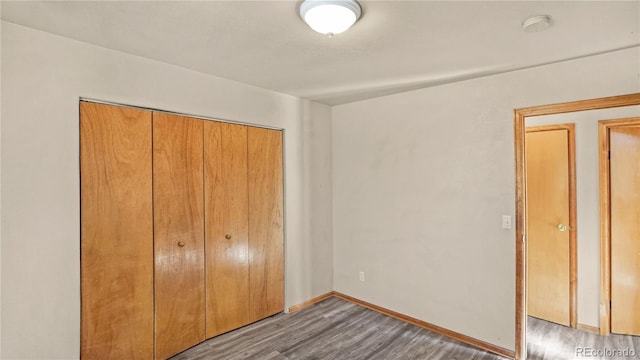 unfurnished bedroom featuring dark hardwood / wood-style flooring and a closet