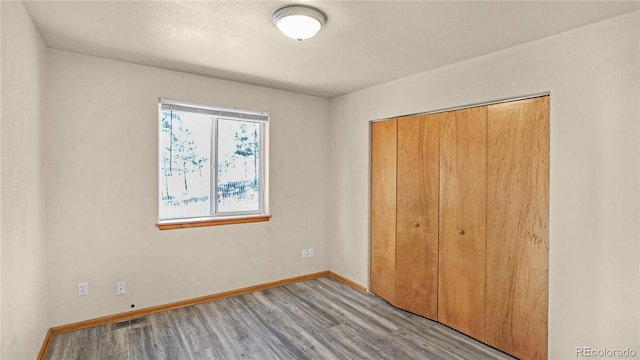 unfurnished bedroom with light wood-type flooring and a closet