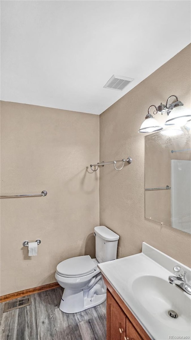 bathroom featuring vanity, toilet, and wood-type flooring