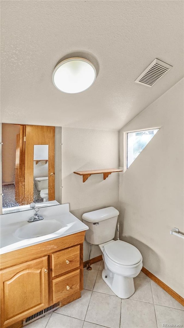 bathroom with vanity, a textured ceiling, tile patterned floors, and toilet