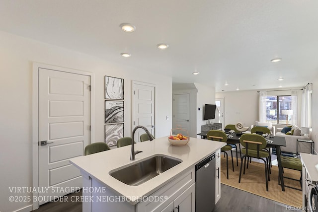 kitchen with a kitchen island with sink, sink, dishwasher, dark wood-type flooring, and white cabinets