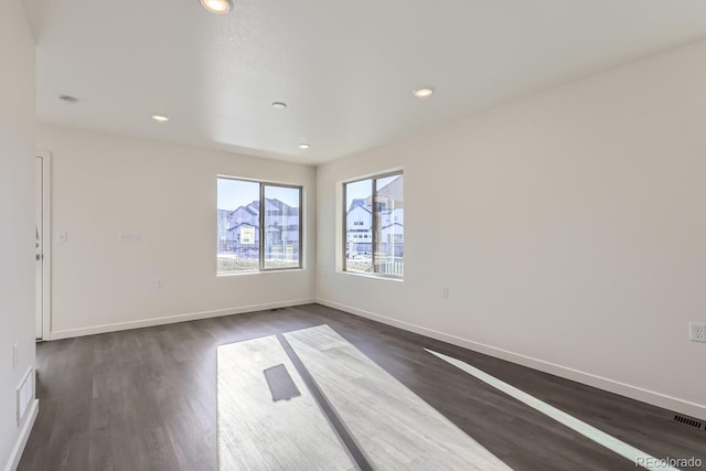 unfurnished room with dark wood-type flooring