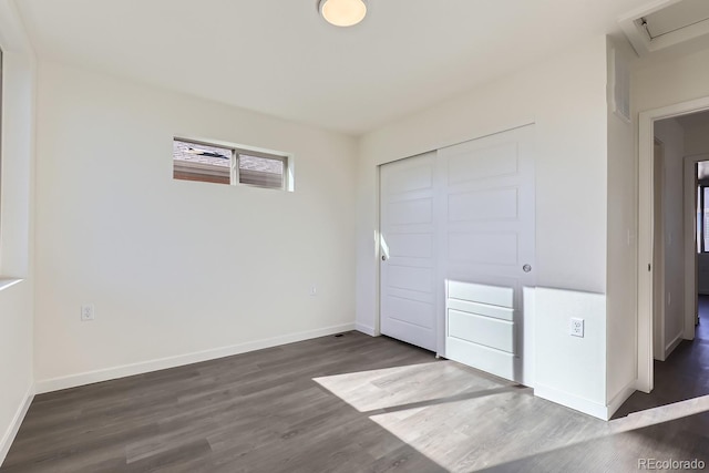 unfurnished bedroom featuring a closet and dark hardwood / wood-style flooring