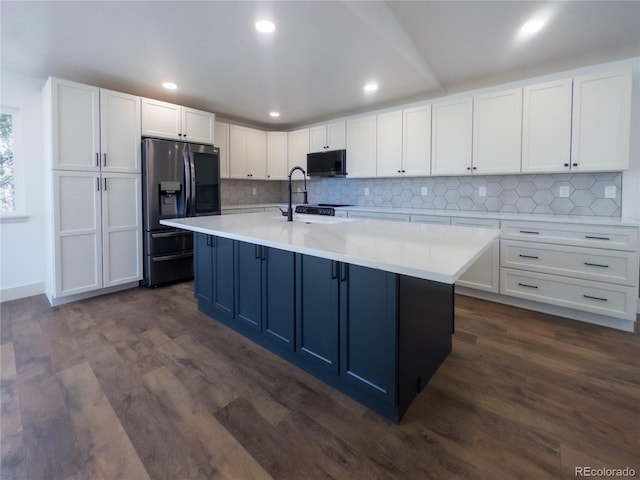 14546 Pine View Rd, Larkspur, CO 80118 - kitchen featuring stainless steel refrigerator with ice dispenser, black microwave, white cabinets, light countertops, and tasteful backsplash