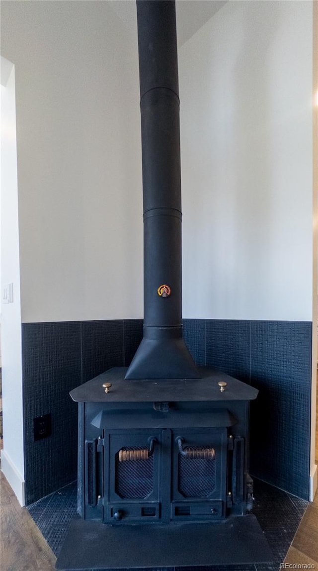 14546 Pine View Rd, Larkspur, CO 80118 - detailed view of a wood stove, tile walls, wainscoting, and wood finished floors