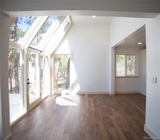 14546 Pine View Rd, Larkspur, CO 80118 - unfurnished living room featuring wood finished floors, vaulted ceiling, baseboards, a skylight, and recessed lighting