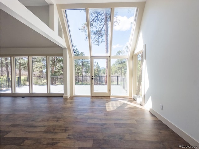 14546 Pine View Rd, Larkspur, CO 80118 - unfurnished living room with a towering ceiling, dark wood finished floors, french doors, and baseboards