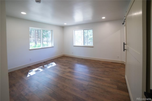 14546 Pine View Rd, Larkspur, CO 80118 - unfurnished room featuring a barn door, dark wood-style floors, recessed lighting, baseboards, and a smoke detector