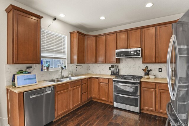 kitchen with dark wood-type flooring, appliances with stainless steel finishes, decorative backsplash, and sink