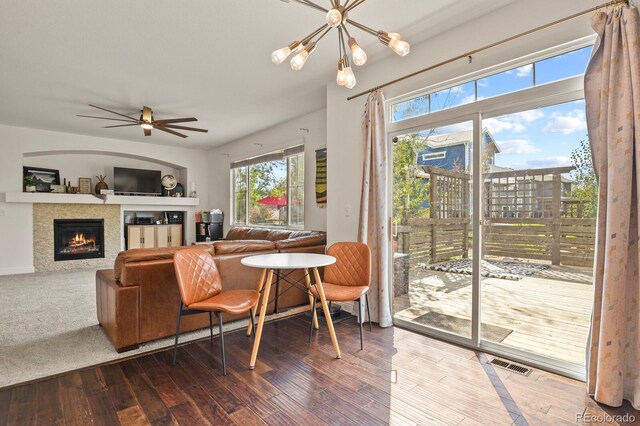 living room featuring ceiling fan with notable chandelier and hardwood / wood-style flooring