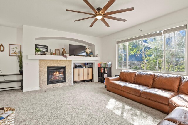 carpeted living room with ceiling fan, a wealth of natural light, and a fireplace