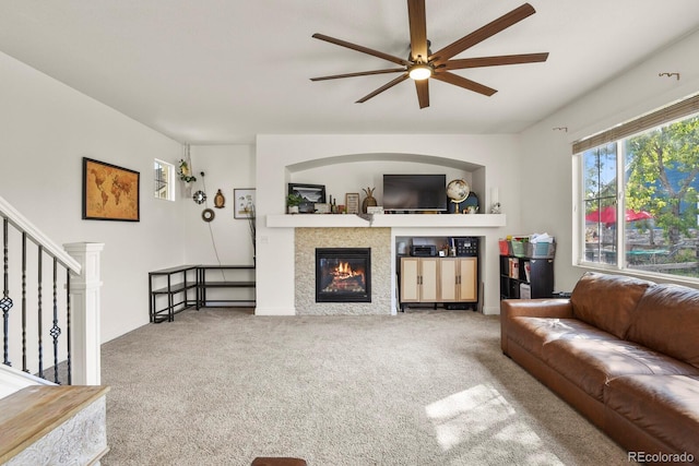 carpeted living room with a fireplace and ceiling fan