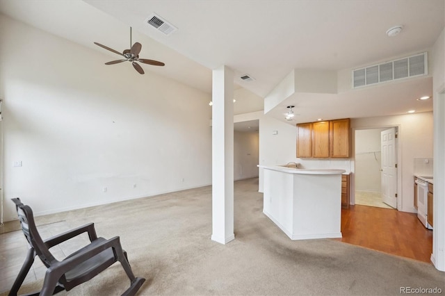 10725 Eliot Cir Unit 102, Denver, CO 80234 - kitchen with a ceiling fan, open floor plan, light carpet, and a towering ceiling