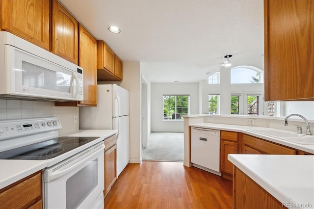 10725 Eliot Cir Unit 102, Denver, CO 80234 - kitchen with white appliances, a sink, light wood-style floors, brown cabinets, and a ceiling fan