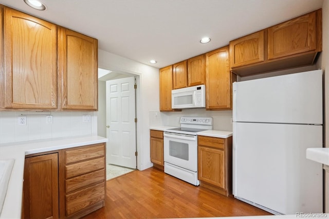 10725 Eliot Cir Unit 102, Denver, CO 80234 - kitchen with white appliances, light wood finished floors, recessed lighting, light countertops, and tasteful backsplash