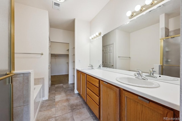 10725 Eliot Cir Unit 102, Denver, CO 80234 - full bathroom with double vanity, a stall shower, a garden tub, and a spacious closet