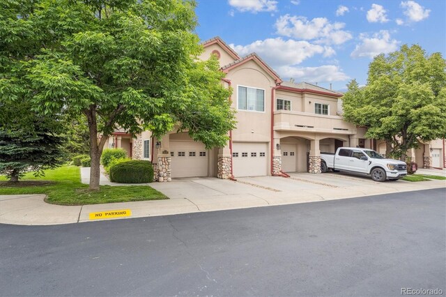 10725 Eliot Cir Unit 102, Denver, CO 80234 - multi unit property with stucco siding, driveway, stone siding, and an attached garage