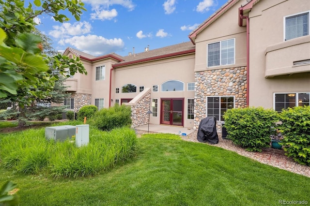 10725 Eliot Cir Unit 102, Denver, CO 80234 - rear view of property with stone siding, stucco siding, and a lawn