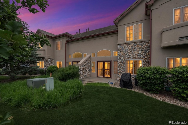 10725 Eliot Cir Unit 102, Denver, CO 80234 - back of house with stone siding, stucco siding, and a yard