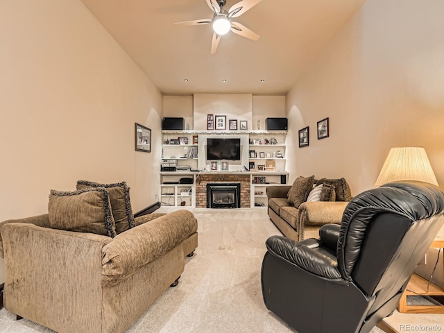 living area with a brick fireplace, light colored carpet, and ceiling fan