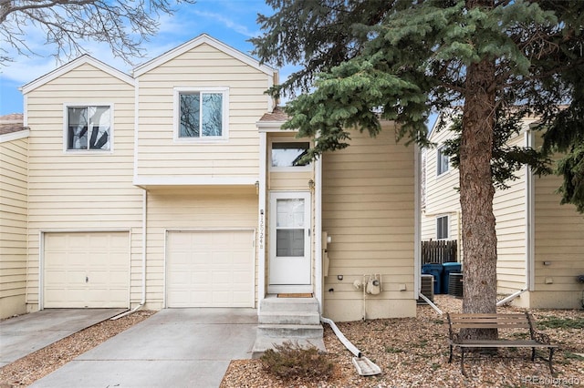 view of front of house with driveway, central AC, and an attached garage