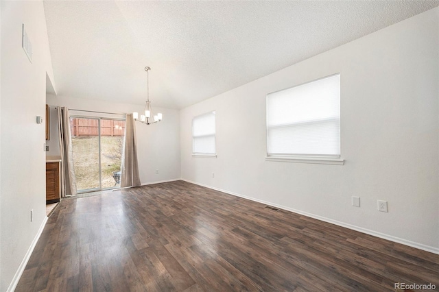 empty room featuring a textured ceiling, dark wood-style flooring, baseboards, and an inviting chandelier