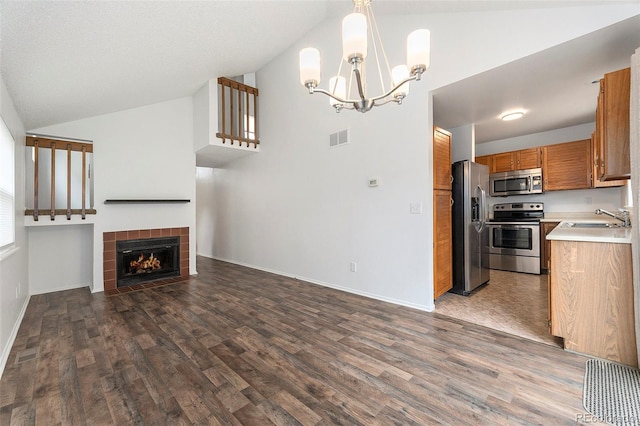 kitchen with visible vents, lofted ceiling, open floor plan, stainless steel appliances, and a sink