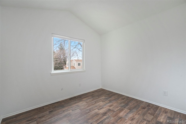 unfurnished room with dark wood-type flooring, lofted ceiling, visible vents, and baseboards