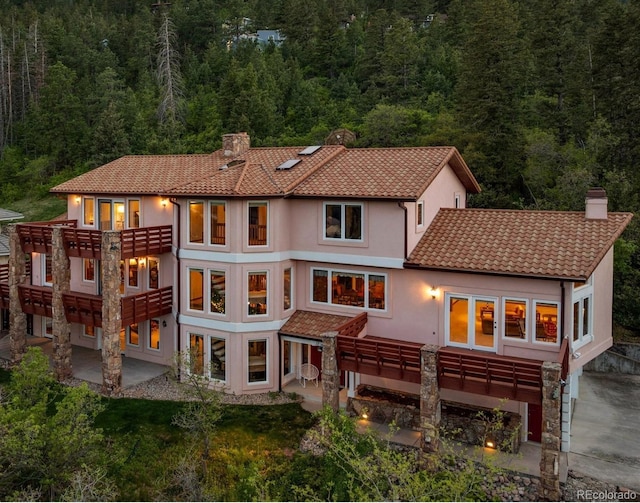 4 Pine Rd, Colorado Springs, CO 80906 - rear view of house featuring a chimney, a view of trees, and a tiled roof