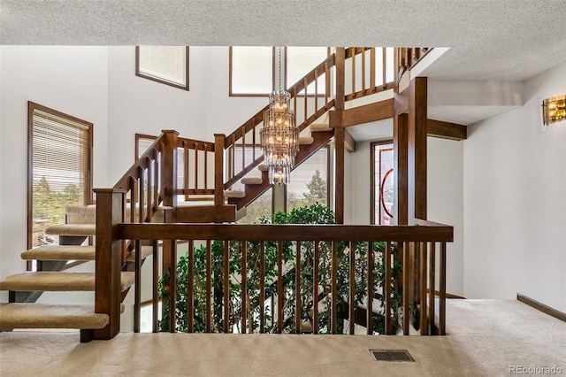 4 Pine Rd, Colorado Springs, CO 80906 - staircase with carpet flooring, a textured ceiling, and a chandelier