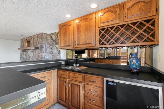 4 Pine Rd, Colorado Springs, CO 80906 - kitchen featuring a textured ceiling, a sink, dark countertops, brown cabinetry, and wine cooler