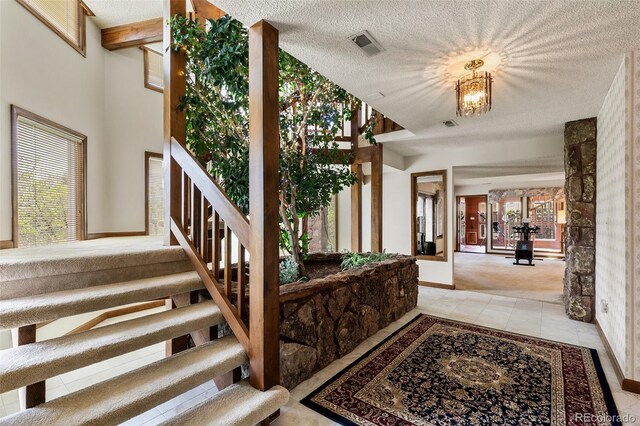 4 Pine Rd, Colorado Springs, CO 80906 - carpeted entrance foyer with stairs, a textured ceiling, baseboards, tile patterned flooring, and plenty of natural light